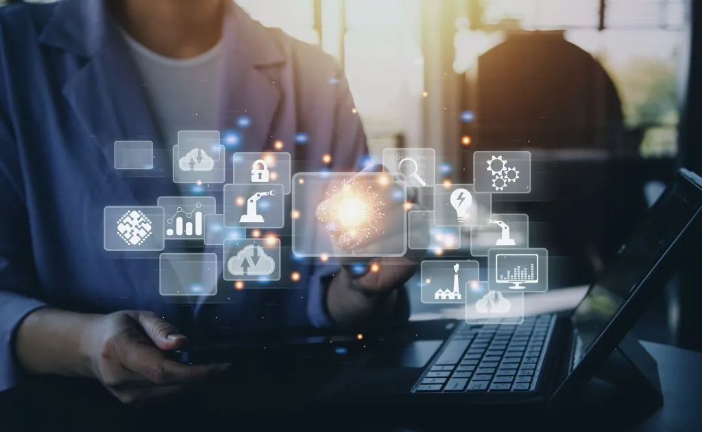 Persona che utilizza un laptop circondata da icone digitali che rappresentano tecnologia e innovazione nell'apprendimento