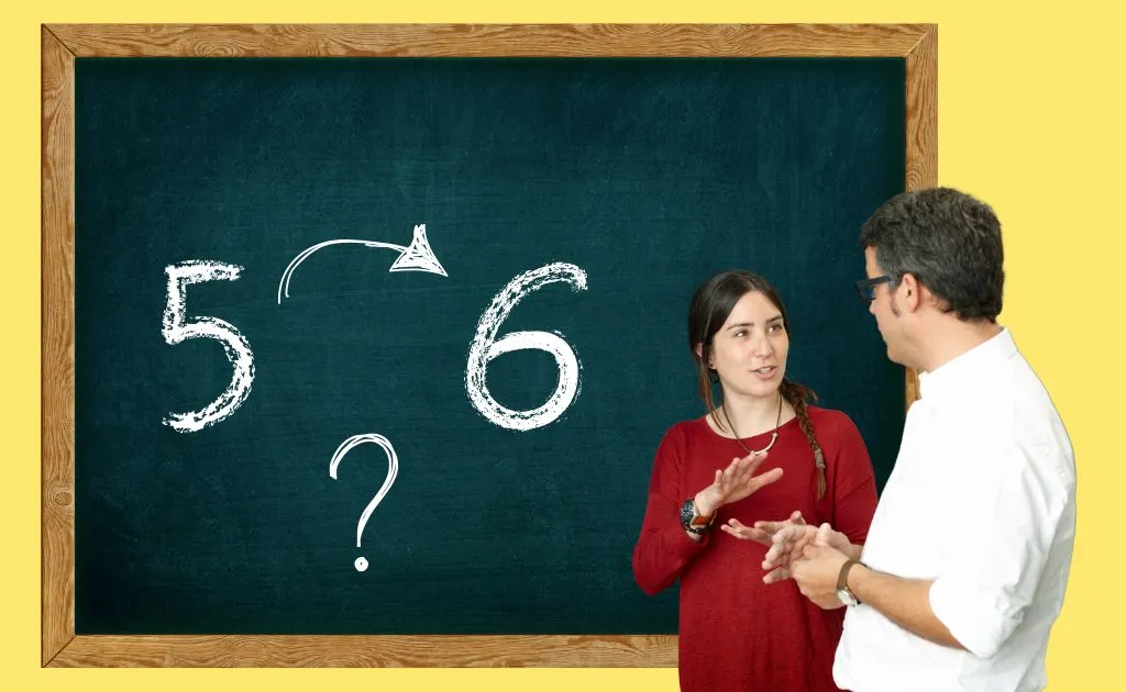 Studentessa e professore discutono davanti alla lavagna con voti scolastici durante una sessione di recupero